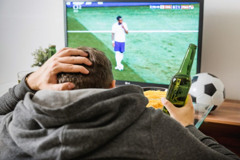 A distraught man watching a soccer match