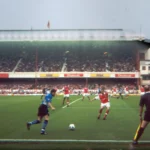 This image features a match between Arsenal and Sheffield Wednesday, two prominent football clubs in England. It captures the intensity of the match during a 2000s football season.
